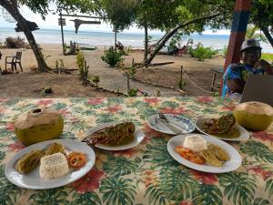 a table with plates of food on the beach at Cabaña y restaurante vikana in Nuquí