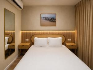 a bedroom with a bed with two nightstands and a bed sidx sidx sidx at Lumi Hotel Eilat - מלון בוטיק באילת in Eilat +31 photos