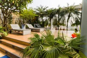 a patio with a bunch of chairs and palm trees at FARS Hotel & Resorts - BAR-Buffet-Pool-SPA in Dhaka