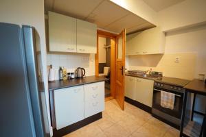 a kitchen with white cabinets and a black counter top at Studio v Aldrovském Triu in Vítkovice