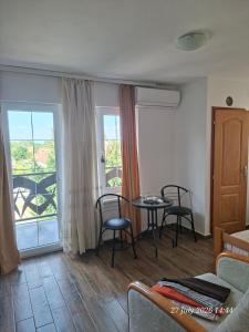 a living room with a table and chairs and a balcony at EasyHedonist in Stara Pazova