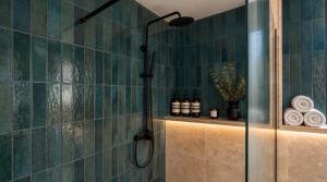 a shower in a bathroom with green tiles at St Anne Palace by Tritoni Prestige in Il-Furjana +18 photos