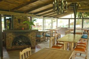 a restaurant with a fireplace and tables and chairs at Palmas de Cocora in Salento