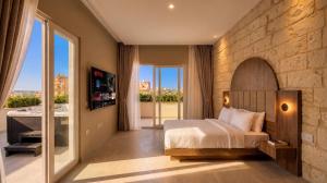 a bedroom with a bed and a balcony with a tub at St Anne Palace by Tritoni Prestige in Il-Furjana