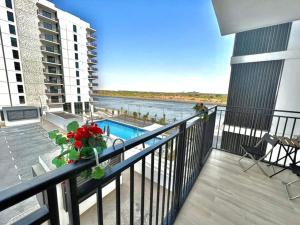 a balcony with a pool and a view of the water at Waterfront Yas 1BR near F1 & Ticket Savings in Abu Dhabi