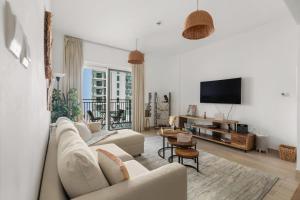 a living room with a couch and a tv at Waterfront Yas 1BR near F1 & Ticket Savings in Abu Dhabi