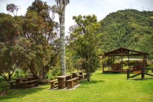 a park with picnic tables and a gazebo at Palmas de Cocora in Salento
