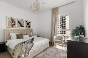 a bedroom with a large bed and a chandelier at Waterfront Yas 1BR near F1 & Ticket Savings in Abu Dhabi +45 photos