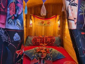 a room with a bed in a tent with a woman on it at Roulotte de Charme in Bréconchaux