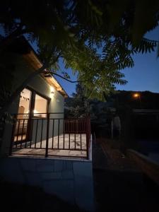 a house with a balcony with a gate at night at Hidden Hills Cottage Sarajevo in Sarajevo