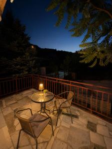 a table and chairs on a patio at night at Hidden Hills Cottage Sarajevo in Sarajevo