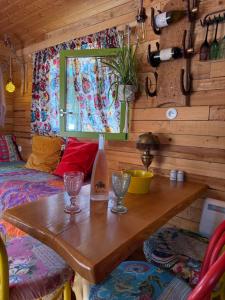 a room with a wooden table with wine bottles on it at Roulotte de Charme in Bréconchaux