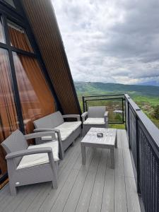 a balcony with chairs and a table and a view at Mravaldzali twins in Oni +7 photos