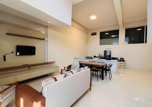 a living room with a table and chairs and a kitchen at Abaíra Serra Azul Suítes 03 - Centro in Petrolina