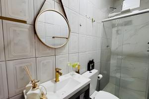 a bathroom with a sink and a mirror and a toilet at Abaíra Serra Azul Suítes 01 - Centro in Petrolina +10 photos