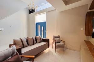 a living room with a couch and a chair at Abaíra Serra Azul Suítes 01 - Centro in Petrolina