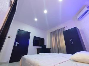 a bedroom with two beds and a flat screen tv at IBK's Hotels and Suites in Rumuola