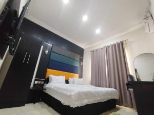 a bedroom with a large bed with a blue and orange wall at IBK's Hotels and Suites in Rumuola