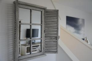 ein altes Fenster mit einem TV in einem Zimmer in der Unterkunft Ferienhaus MeeresRauschen in Olpenitz
