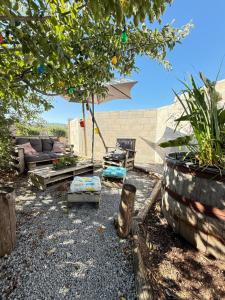 a patio with a couch and an umbrella at Roulotte de Charme in Bréconchaux