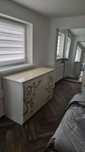 a bedroom with a bed and a dresser with a window at Гостинний дім in Shom