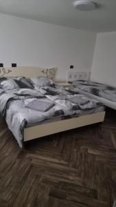 two beds in a bedroom with a wooden floor at Гостинний дім in Shom