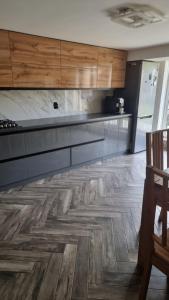 a kitchen with wooden cabinets and a wooden floor at Гостинний дім in Shom