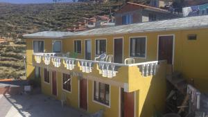 a yellow building with clothes hanging on a balcony at Ecolodge Amanecer in Comunidad Yumani