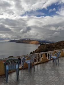 two chairs sitting on a balcony overlooking a body of water at Ecolodge Amanecer in Comunidad Yumani