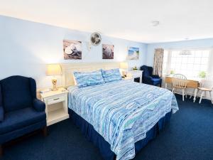 a bedroom with a bed with a blue comforter at A Beach Breeze Inn in West Harwich +11 photos
