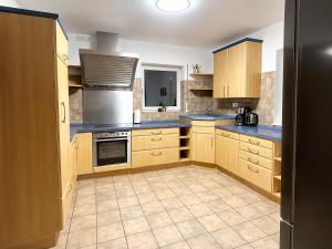a large kitchen with wooden cabinets and appliances at Rheinview Sunset in Urbar in Urbar