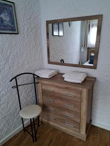 a bathroom with a dresser with a mirror and a chair at Can Teixidor in Besalú +26 photos