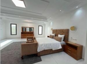 a bedroom with a large bed and a chair at m hadji premium in Dakar