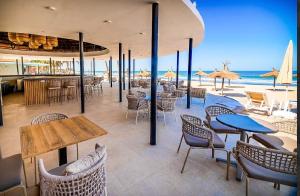 a restaurant with tables and chairs and the beach at m hadji premium in Dakar