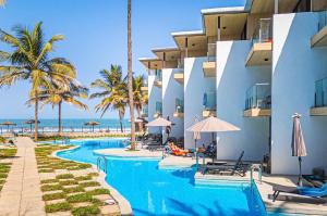 a hotel with a swimming pool next to the beach at m hadji premium in Dakar