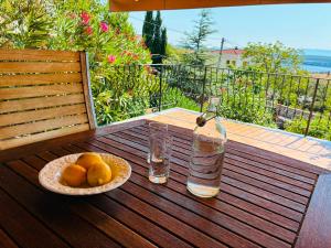 a bowl of oranges and a glass of water on a balcony at Holiday Sparks in Jadranovo