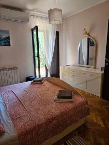a bedroom with a bed with a dresser and a mirror at Holiday Sparks in Jadranovo +22 photos