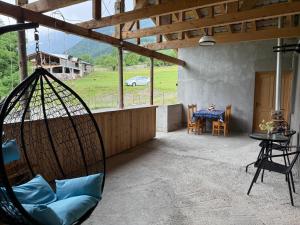 a swing hanging from the ceiling of a house with a table at Tebdi Qor, Warm Home in Mestia +12 photos