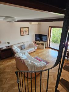 a living room with a couch and a tv at Holiday Sparks in Jadranovo