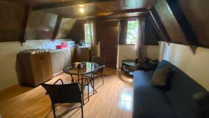 a room with a kitchen and a table and chairs at Cabañita del bosque de la cumbre de san Bartolo Milpas Altas in Guatemala