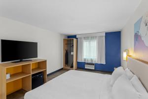 a room with a bed and a flat screen tv at Spark By Hilton Prestonsburg in Prestonsburg
