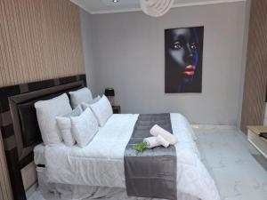 a bedroom with a large bed with a painting on the wall at Ursa lodge in Lubumbashi