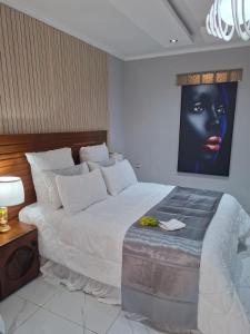 a bedroom with a large bed with a black face on the wall at Ursa lodge in Lubumbashi