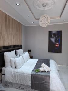 a bedroom with a large bed with a black face on the wall at Ursa lodge in Lubumbashi