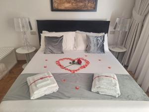 a bed with a heart made out of roses on it at Suite Enea San Rocco in Sperlonga +2 photos
