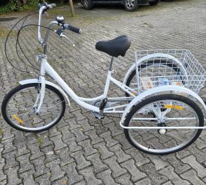 a white bike parked on a street with a basket at Agroturystyka GRAMBURG in Zblewo
