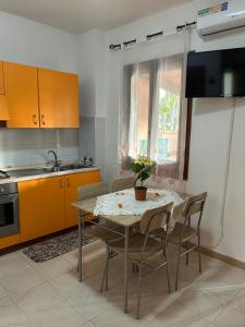 a kitchen with a table with chairs and a sink at Villette Isabella in Parghelia