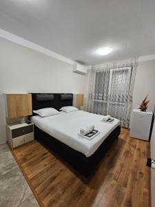 a bedroom with a large bed and a window at Apartments Vilma&Villiam in Ravda