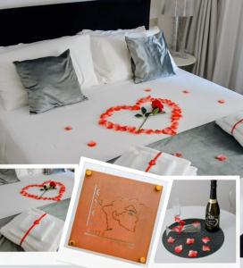 a white bed with red flower decorations on it at Suite Enea San Rocco in Sperlonga