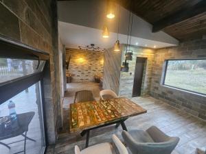 a room with a table and chairs and a brick wall at Къща за гости Жеглица in Zheglitsa